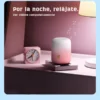 Parlante Bluetooth portátil Remax Aircity rosado sobre la mesa de noche junto a un reloj
