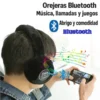Persona con audífonos de peluche negros usando un teléfono, con símbolos de música y Bluetooth.