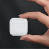 Mano sosteniendo el estuche compacto de los audífonos inalámbricos para celular Remax TWS-10
