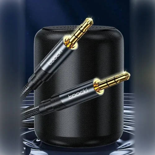 Cable auxiliar para carro Toocki con conectores jack 3.5 mm dorados junto a un parlante