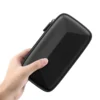 Mano sosteniendo el estuche rígido para accesorios electrónicos Usams JANE06 negro