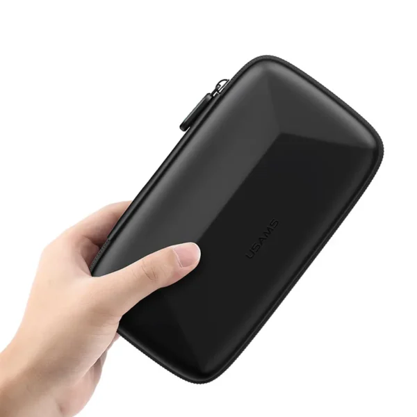 Mano sosteniendo el estuche rígido para accesorios electrónicos Usams JANE06 negro