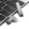 Dos pendrives Usams ZB198 junto al teclado de una laptop, uno con el conector USB 3.0 y otro con el USB-C