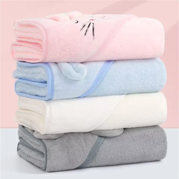 Toallas con capucha dobladas en rosado, celeste, blanco y gris, apiladas para mostrar las opciones de color.