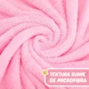 Primer plano de la microfibra rosada enrollada, con una leyenda sobre su textura suave.